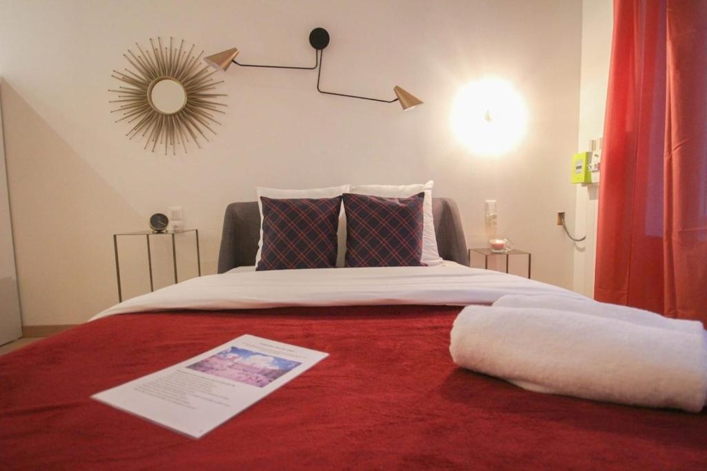 une chambre avec un grand lit avec une couverture rouge dans l'établissement Lille Centre - Superb equipped studio!, à Lille