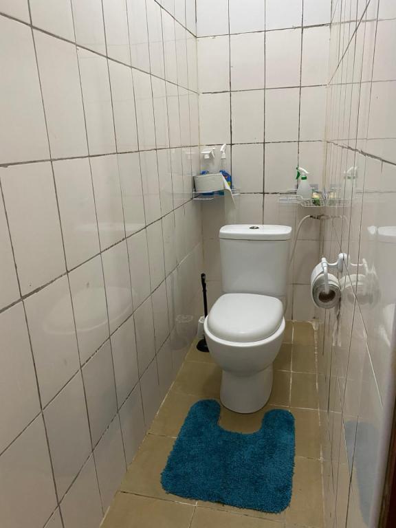 ディアニ・ビーチにあるDiani Budget Homesのバスルーム(白いトイレ、青い敷物付)