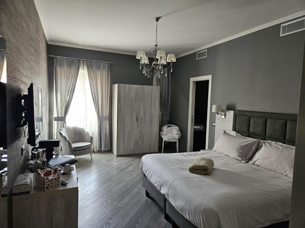 サンレモにあるPrimafila Premium Guest Houseのベッドルーム1室(ベッド1台付)、椅子付きのベッドルーム1室が備わります。