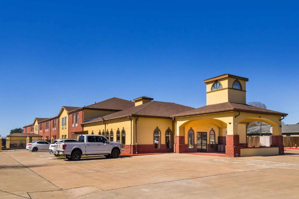 un edificio con una torre dell'orologio in un parcheggio di Quality Inn Bay City TX a Bay City