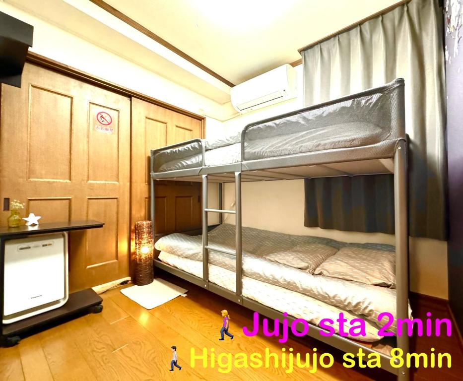 two bunk beds in a room with a tv at 3 Best location small private room!cozy place in JUJO shopping street in Tokyo