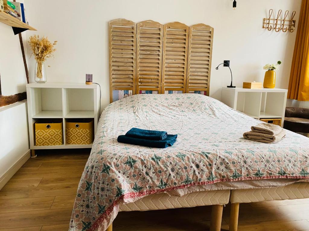 une chambre avec un lit avec une couverture dessus dans l'établissement Studio au calme avec terrasse - hauteurs de Rouen, à Bihorel