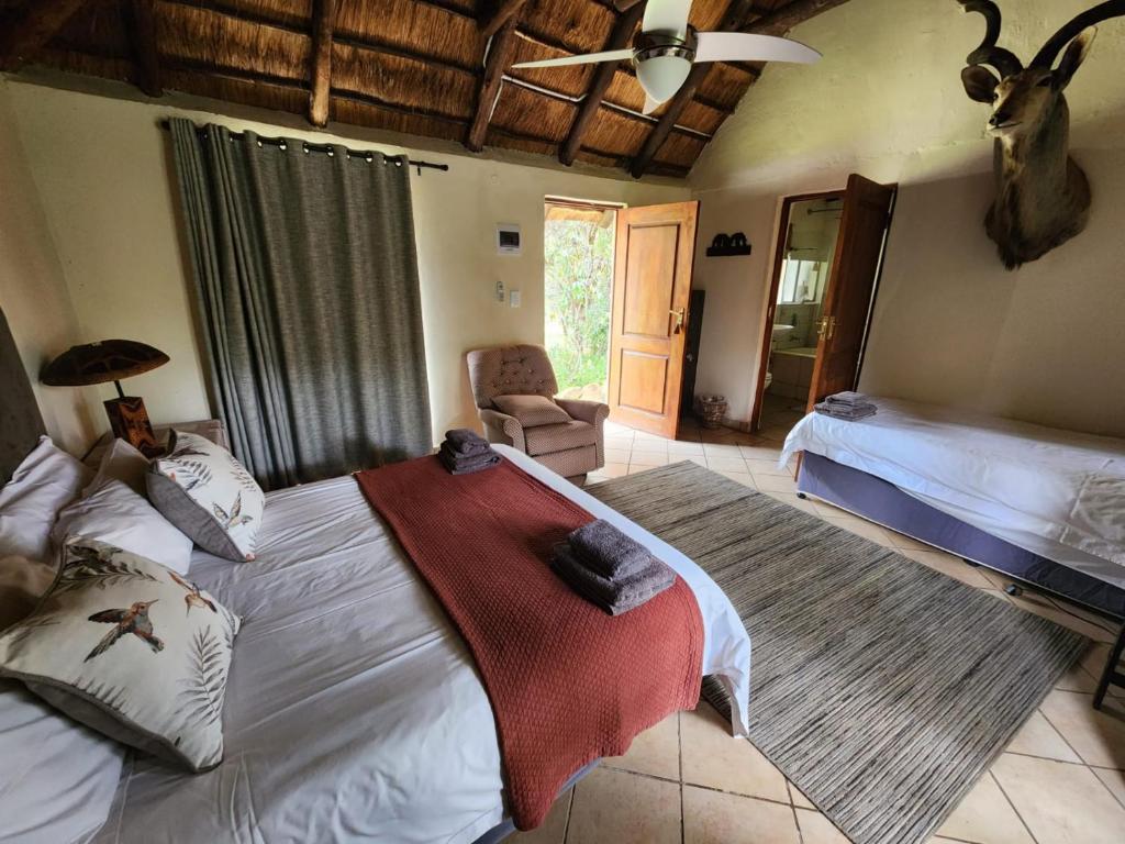 a bedroom with a bed and a chair in a room at Lama Lama Game Reserve in Mount Hope
