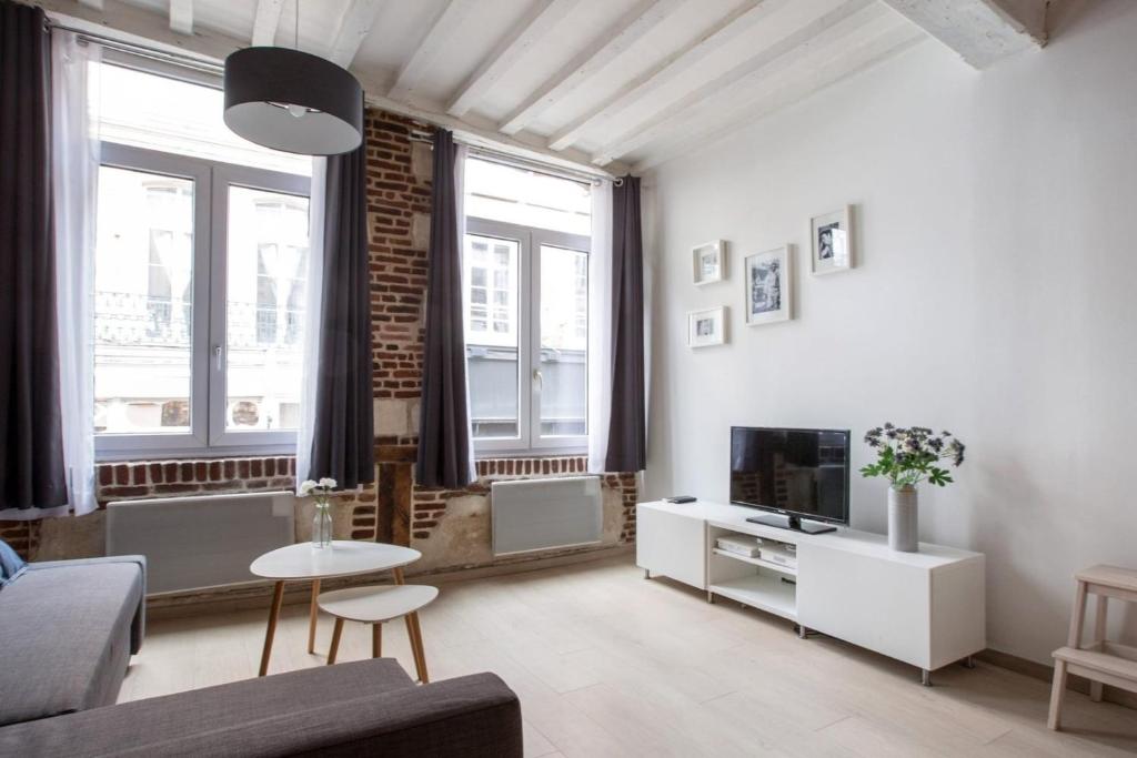 un soggiorno con divano e TV di Old Town - Superb apartment in rue Esquermoise ! a Lille