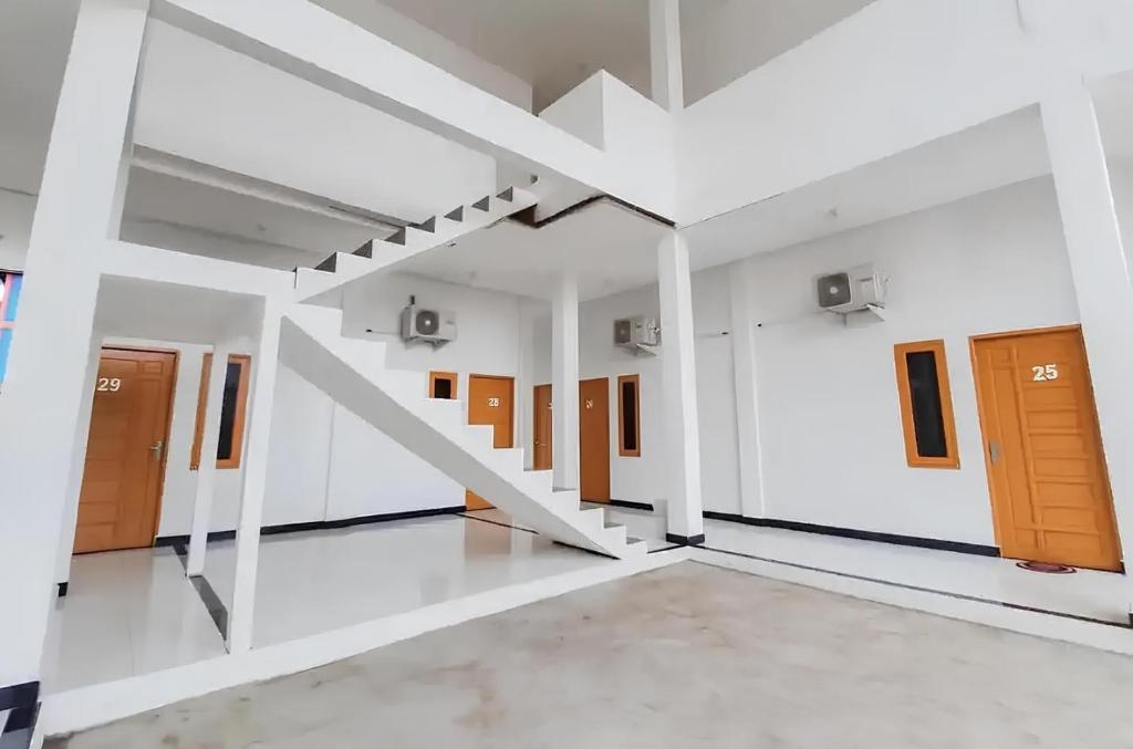um quarto vazio com escadas num edifício em OYO 93306 Homestay Permana Supadio Airport em Pontianak