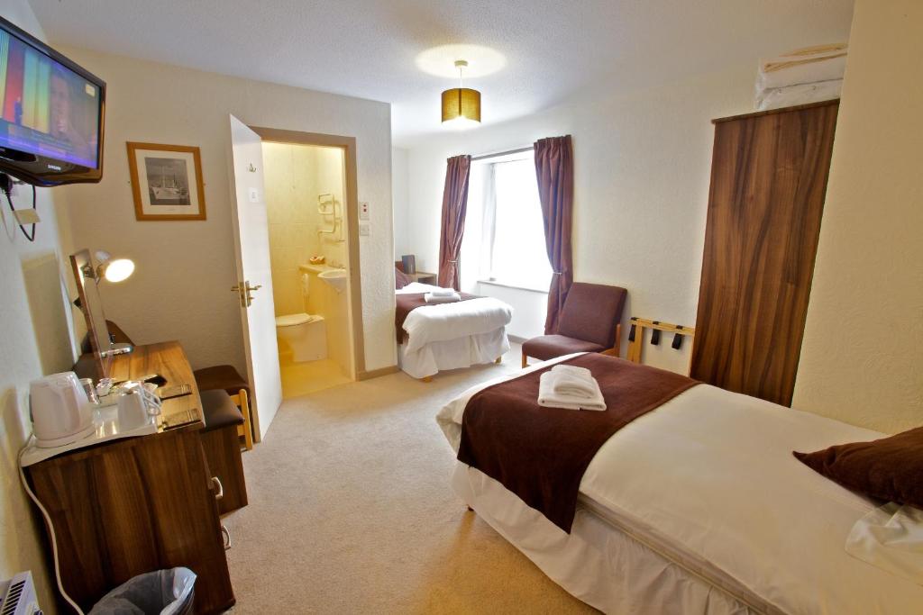a hotel room with two beds and a television at St Ola Hotel in Kirkwall