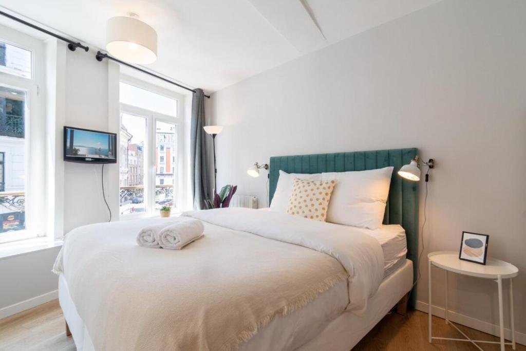 une chambre avec un grand lit blanc avec une fenêtre dans l'établissement Lille Hypercentre/Train station-Superb studio, à Lille