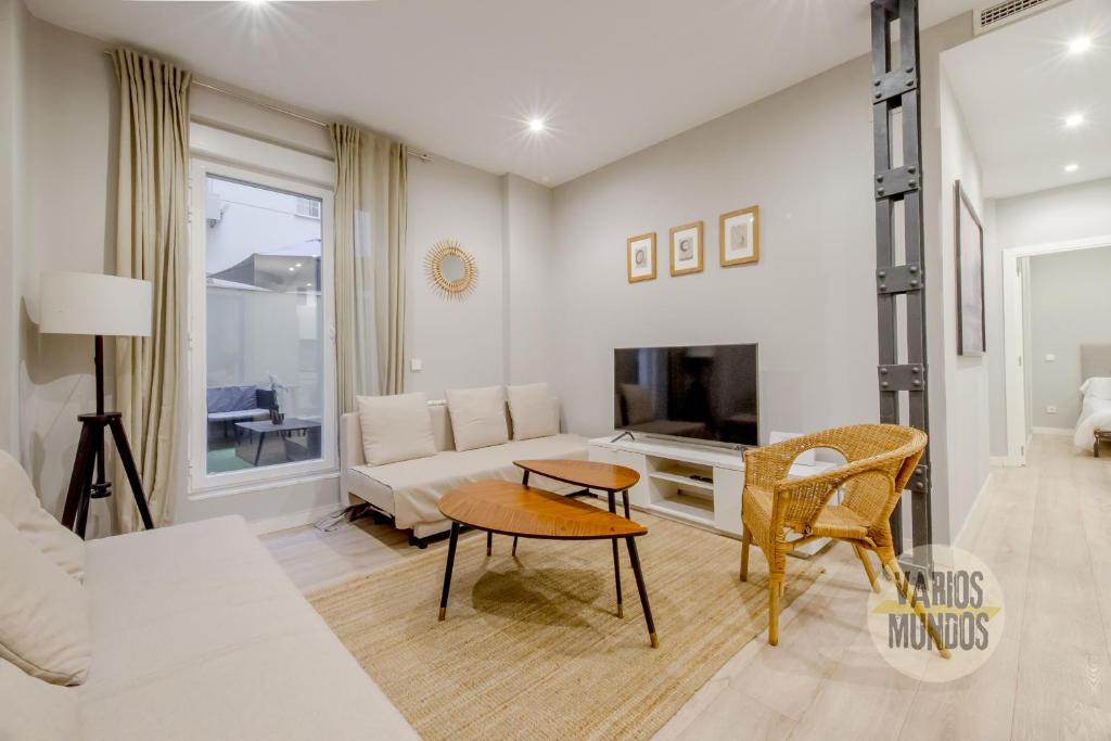 uma sala de estar com um sofá e uma televisão em Acogedor Apt 3 habitaciones y terraza en el Centro de Madrid em Madrid