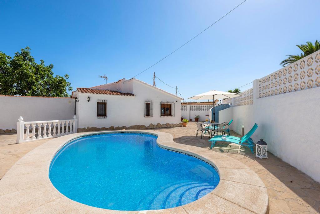 a swimming pool in front of a white house at Villa Maeva - PlusHolidays in Casas de Torrat