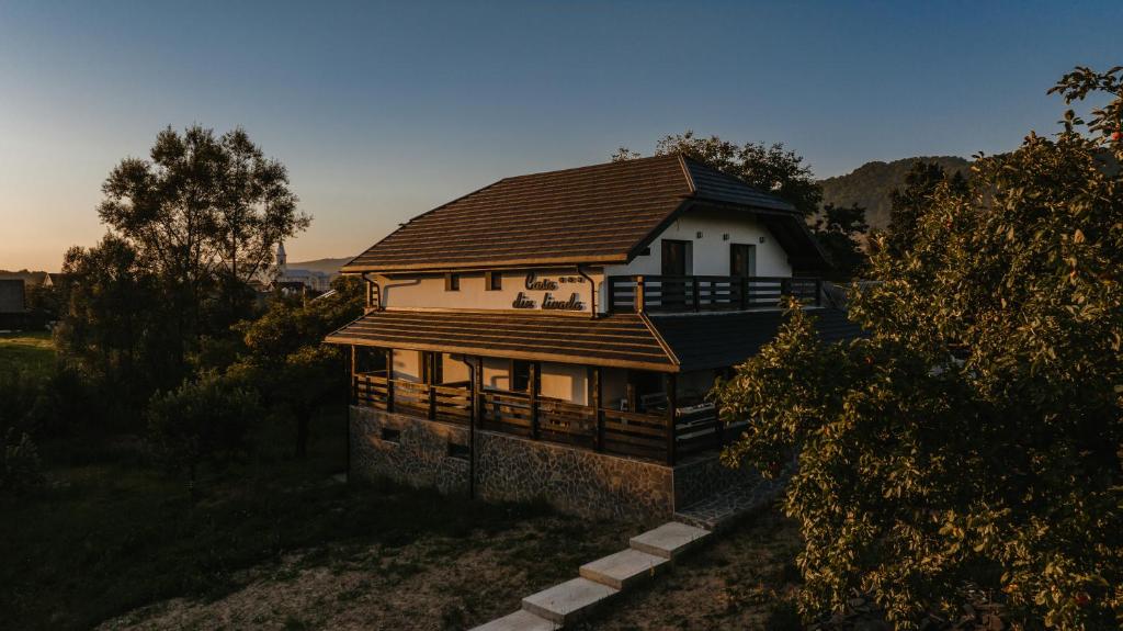 a house with a roof on top of it at Casa din livada in Dragomireşti