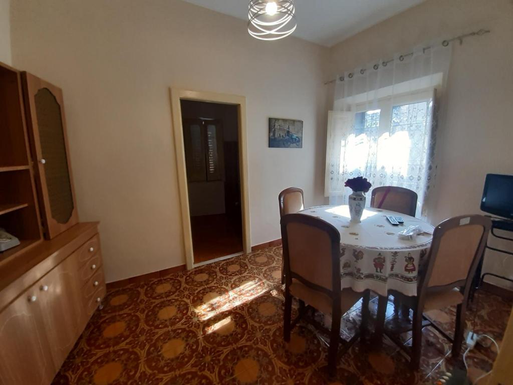 a dining room with a table and chairs and a television at Tindara's House in Francavilla di Sicilia