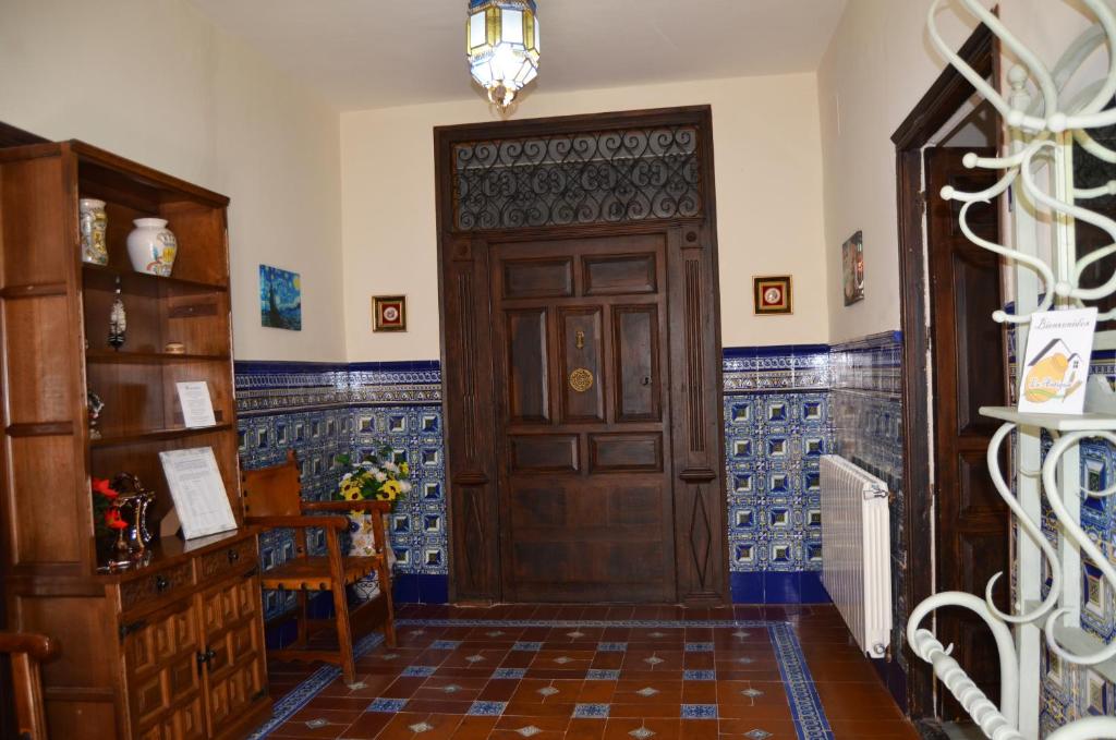 a hallway with a wooden door with blue tiles at La Antigua, casa céntrica, amplio patio y barbacoa in Campillo de Altobuey