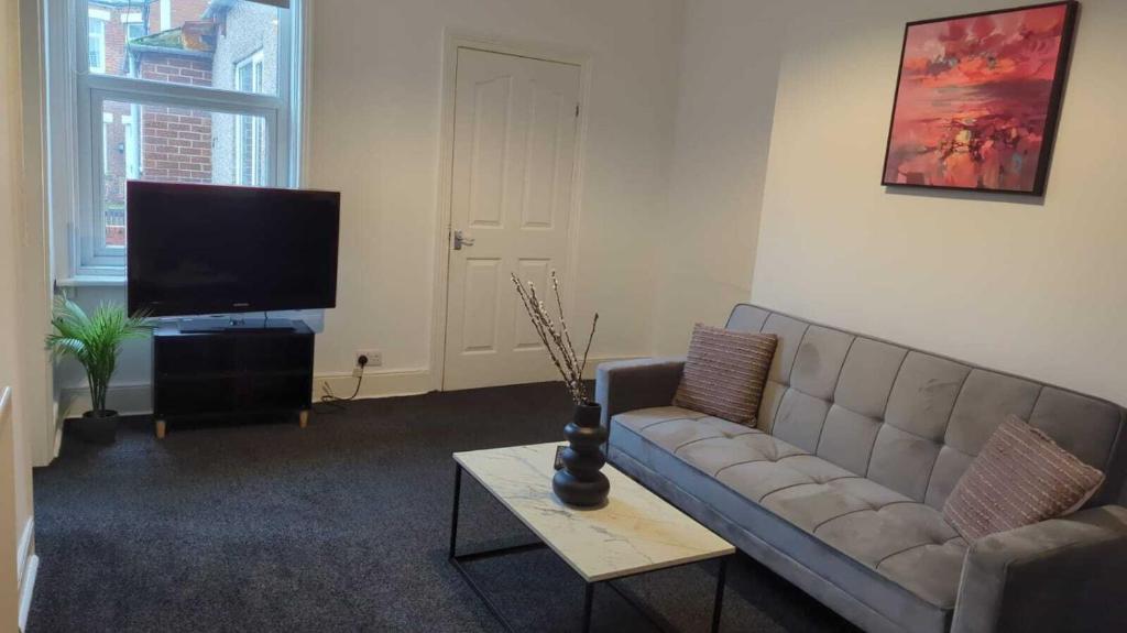 a living room with a couch and a flat screen tv at Alexander Apartments Westoe in South Shields