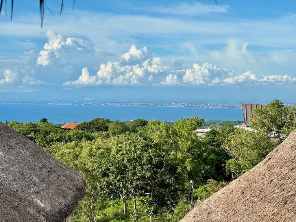 a view of the ocean from a thatch roof at Hillstone Luxury Village in Ungasan