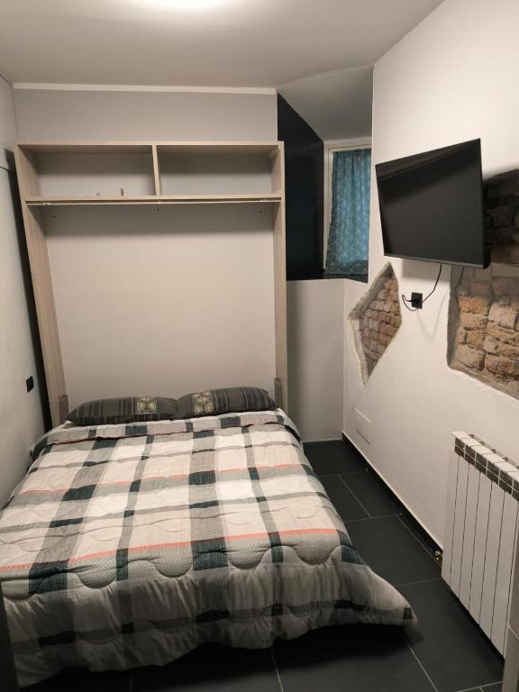 a bedroom with a bed and a flat screen tv at PM 410 Via Delle Forze Armate Guest House in Milan