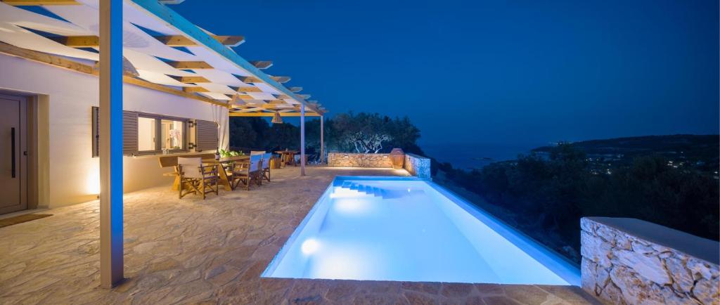 ein Haus mit Pool in der Nacht in der Unterkunft Villa Seva Sea View in Skinária