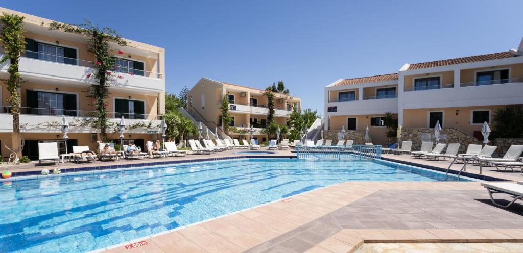 a large swimming pool in front of two buildings at Oscar Hotel in Laganas