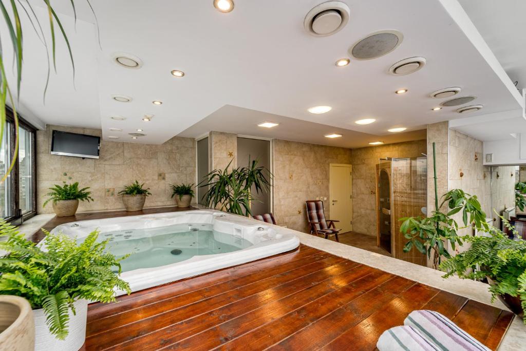 a jacuzzi tub in a room with plants at Apartment Botero in Belgrade