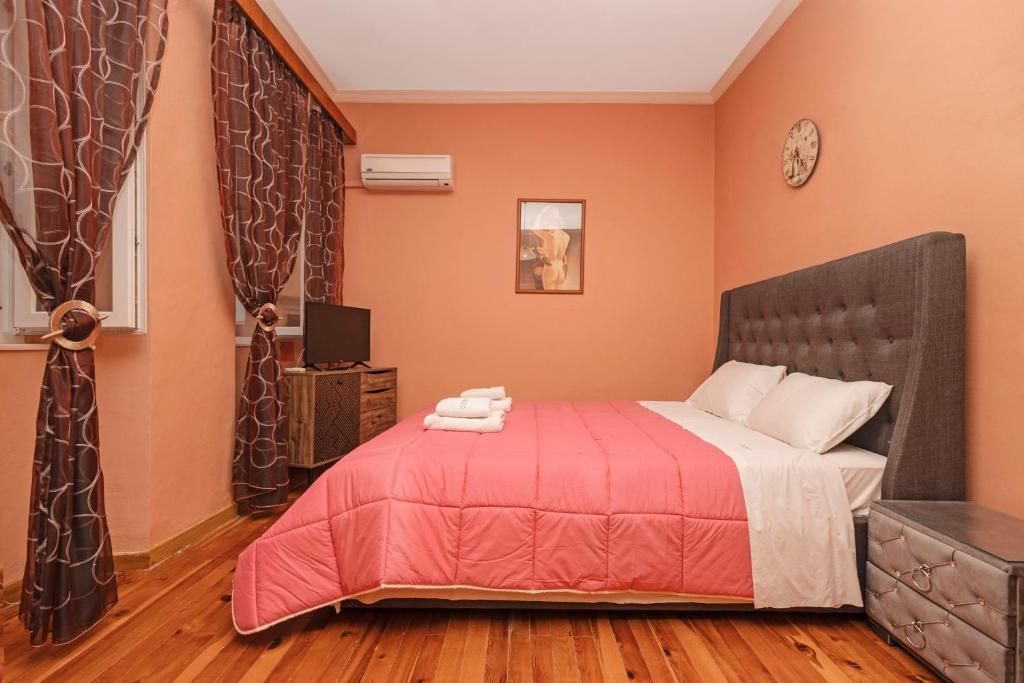Schlafzimmer mit einem Bett mit einer roten Tagesdecke in der Unterkunft Venetian Reale Apartment in Korfu-Stadt