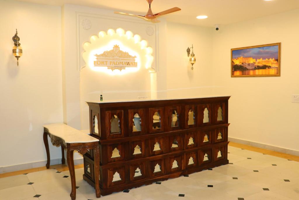 a room with a table and a sign on the wall at Hotel Fort Padmawati in Pratāpgarh
