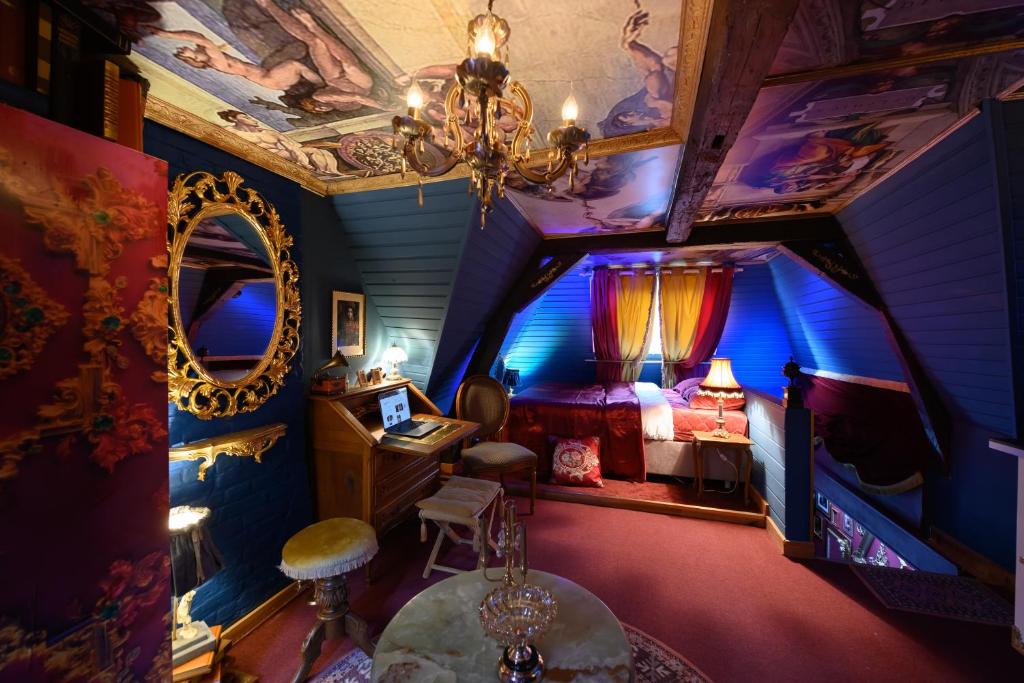 Habitación en el ático con cama y espejo en Charme baroque/Séjour romantique, en Mons
