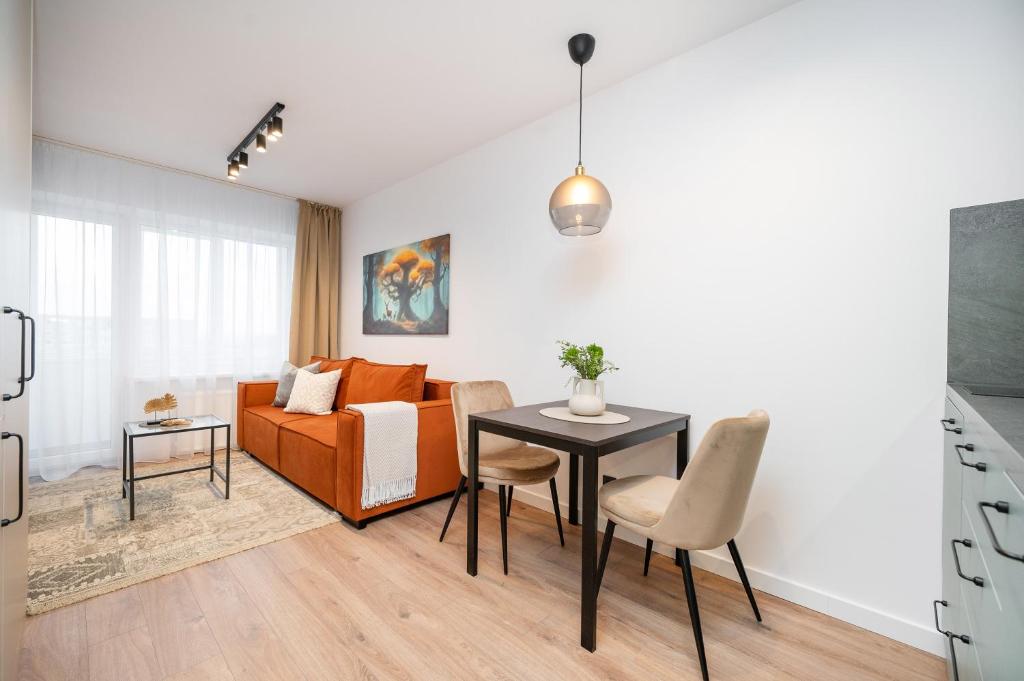 een woonkamer met een tafel en een bank bij Apartments near Akropolis shopping center. in Vilnius