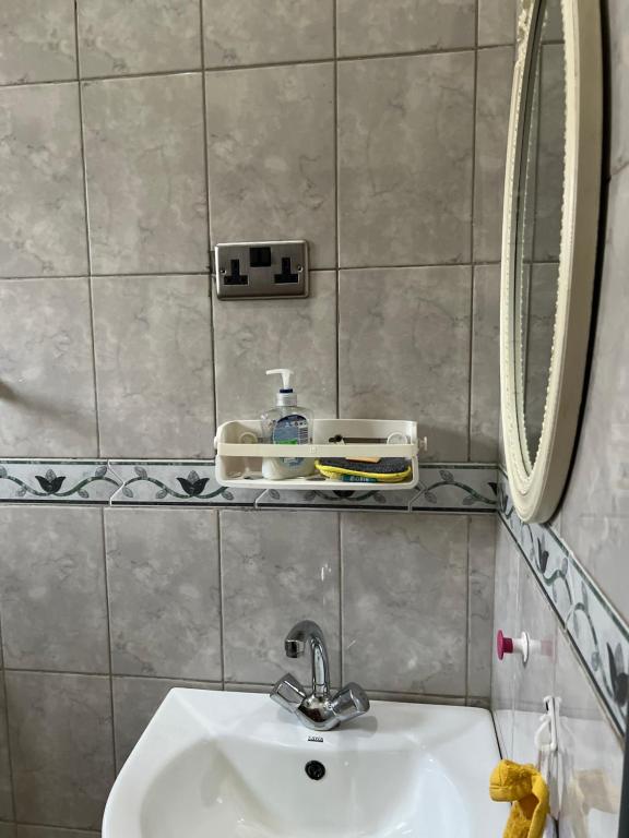 y baño con lavabo y espejo. en Tropical Oasis Retreat, en Kisubi