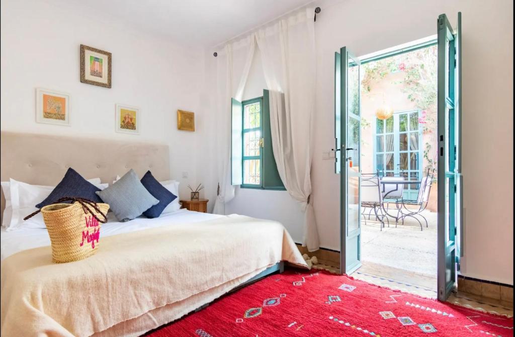 - une chambre avec un lit et une porte coulissante en verre dans l'établissement Villa Magtafa, à Marrakech