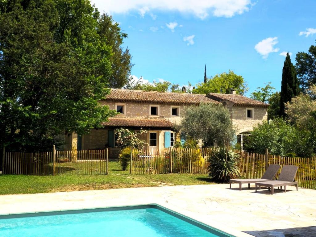 a house with a swimming pool in front of a yard at Mas du Rollier Chambres d'hôtes in Eygalières