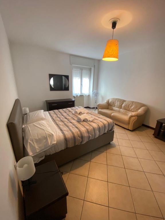 um quarto com uma cama e um sofá em Resegone - City Centre Comfy Apartment em Lecco