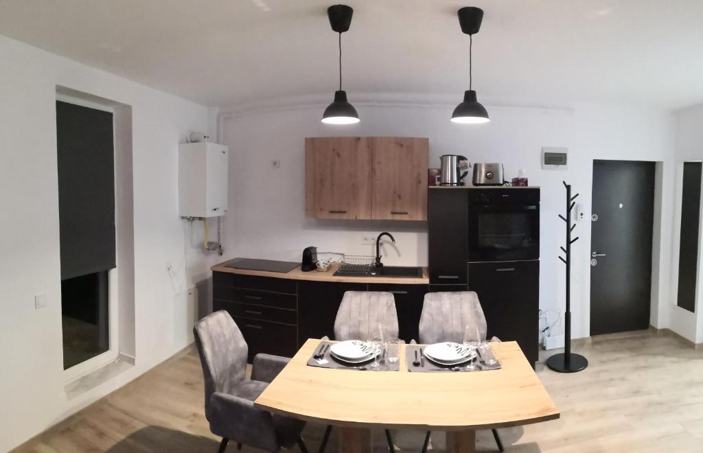 cocina con mesa de madera y sillas en una habitación en Indigo Apartment Urusagului, en Floreşti