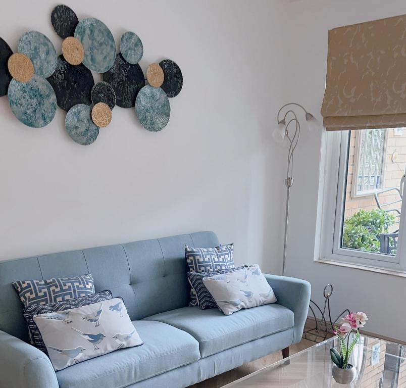 a living room with a blue couch and a window at Beautiful 3 bedroom Apartment in Bournemouth in Bournemouth
