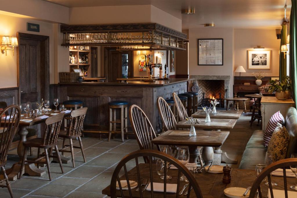 a restaurant with wooden tables and chairs and a bar at The Kirkstyle Inn & Sportsman Rest in Brampton