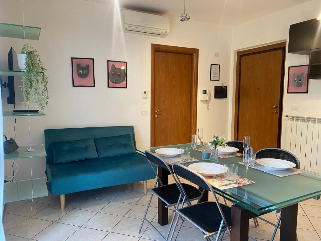 una sala da pranzo con tavolo e divano blu di Campus Pavia Apartment a Pavia