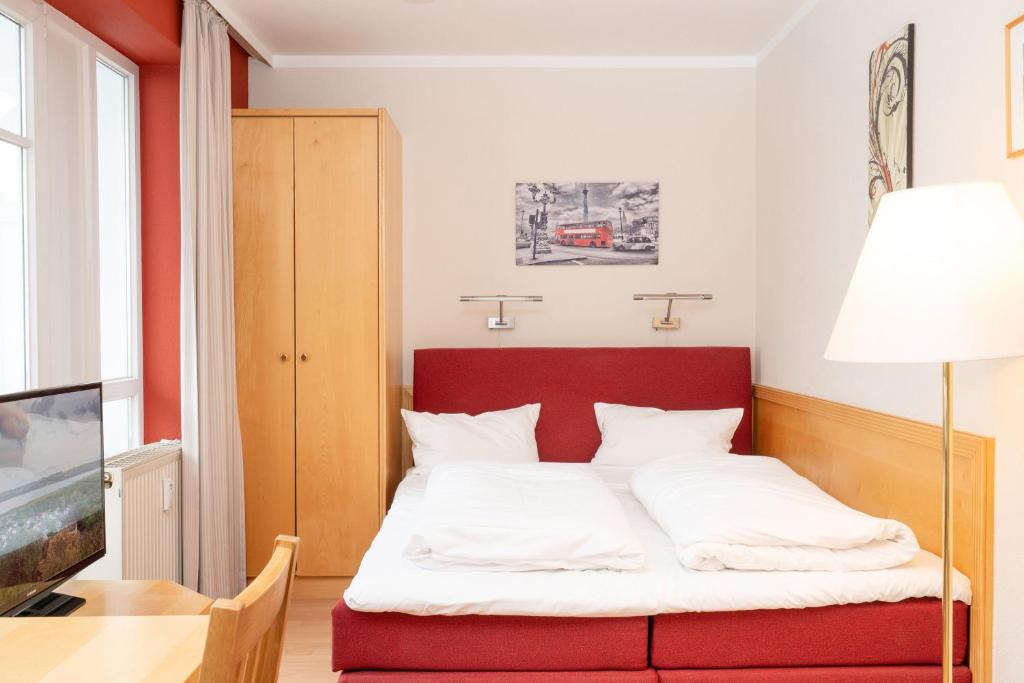 uma cama com uma cabeceira vermelha num quarto em Fewo 601, Seepark Sellin em Ostseebad Sellin