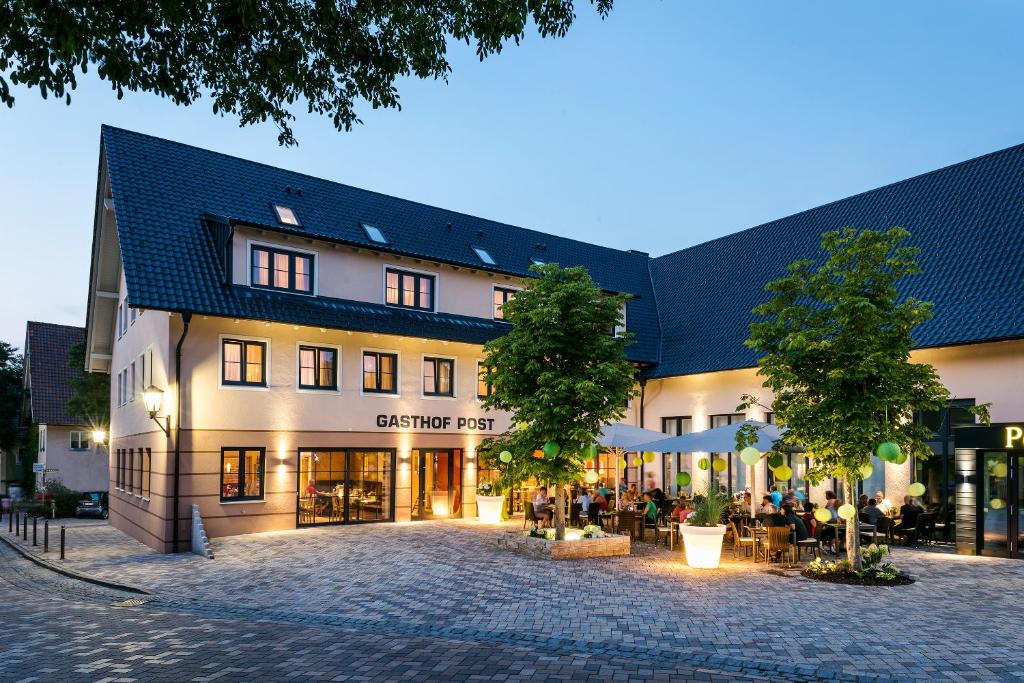 a building with people sitting outside of it at Die Post Hotel in Bad Grönenbach