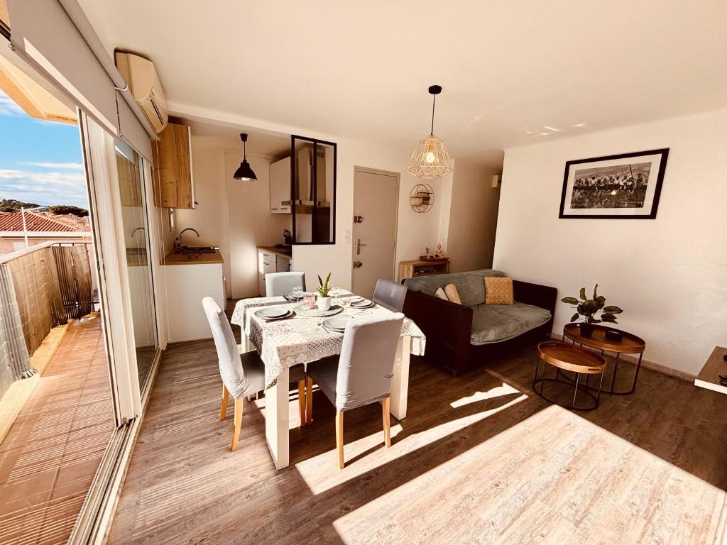 een keuken en een woonkamer met een tafel en stoelen bij T3 Paisible très proche plage in Canet-en-Roussillon