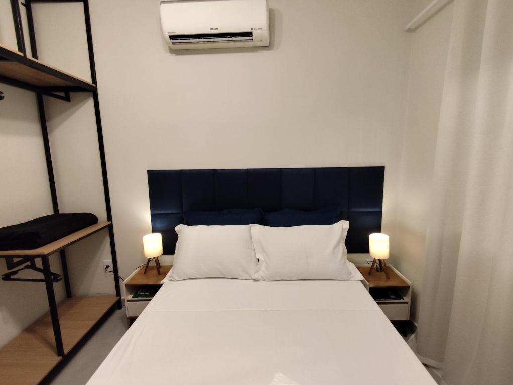 a bedroom with a bed with two lamps on tables at Loft 61 - No coração de Curvelo in Curvelo