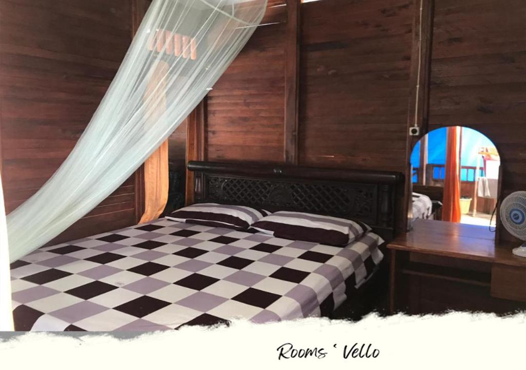 a bedroom with a black and white checkered bed at HEINER HOMESTAY in Bunaken