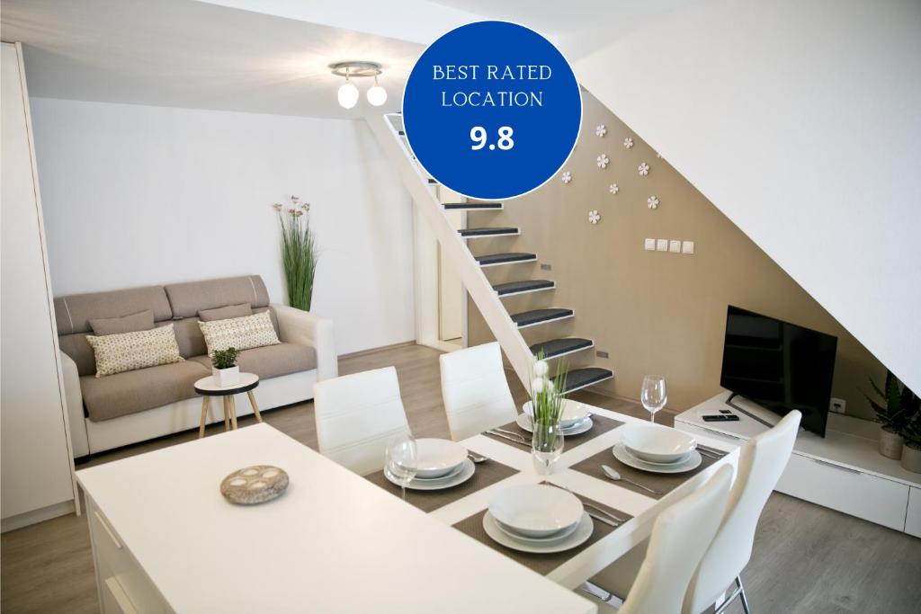a living room with a white table and a staircase at Apartments Hiša Pod Gradom in Ljubljana