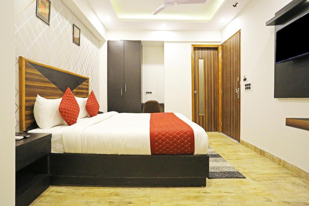 ein Hotelzimmer mit einem Bett und einem TV in der Unterkunft Hotel Casa Suites Near International Airport in Neu-Delhi