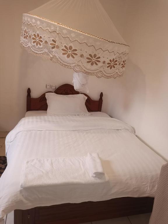 a bedroom with a white bed with a canopy at Alink chinese and korean restaurent in Kigali