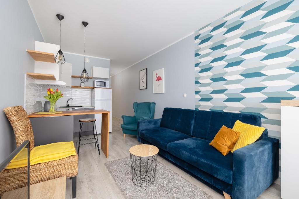 Il comprend un salon avec un canapé bleu et une cuisine. dans l'établissement Potulicka Yellow Studio, à Szczecin