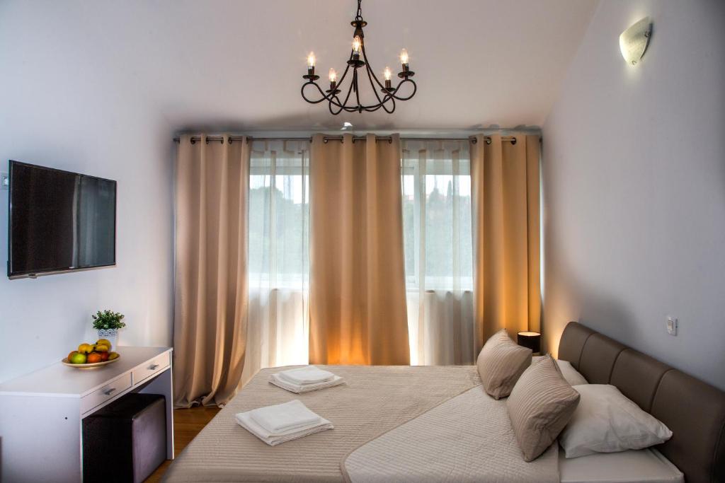 a bedroom with a large bed and a chandelier at Apartment Victoria II in Dubrovnik