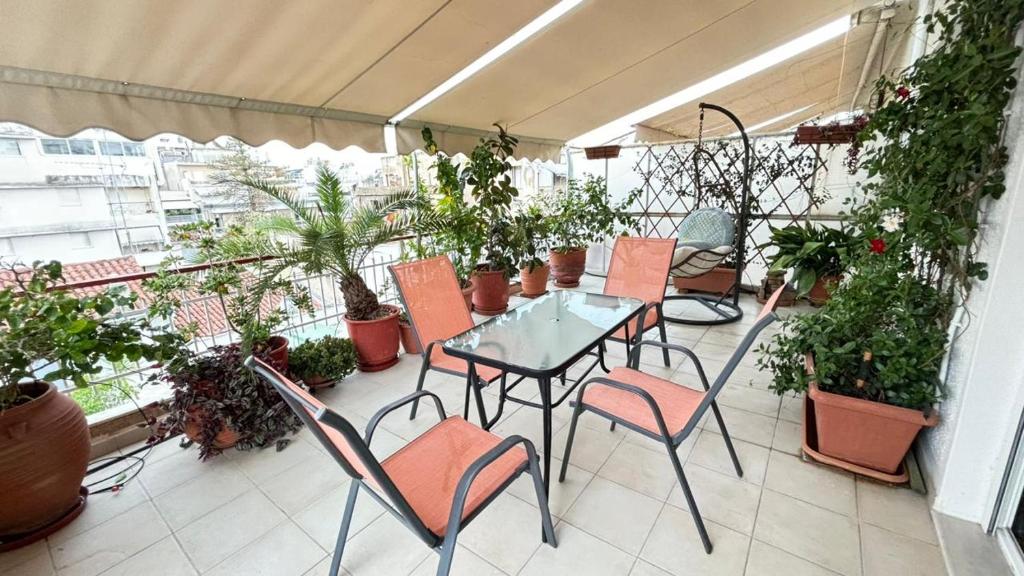 a balcony with a table and chairs and plants at Cozy home in Kypseli in Athens