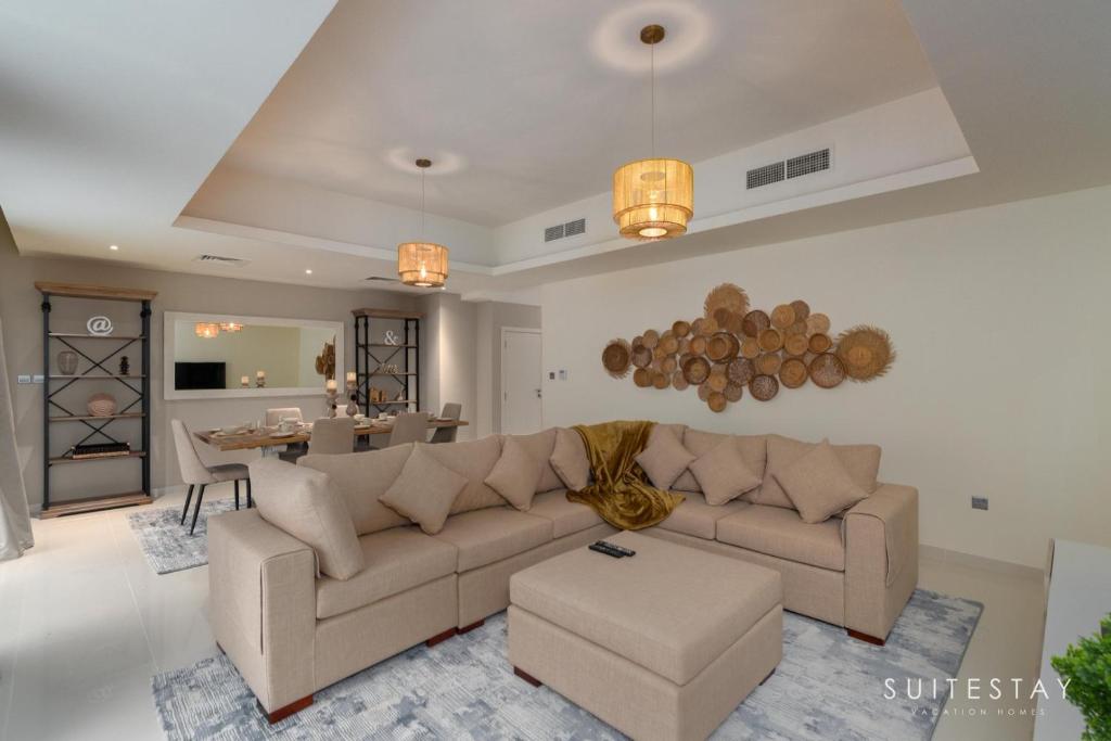 Boho Inspired Large Luxury Villa في دبي: غرفة معيشة مع أريكة وطاولة