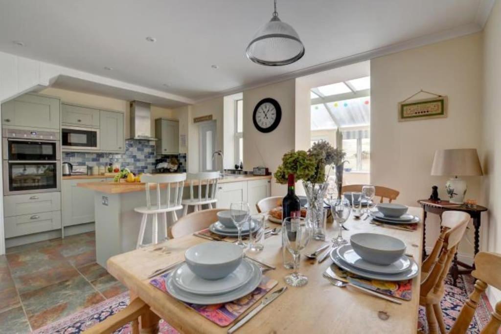 cocina y comedor con mesa de madera y platos en Lynton Exmoor Devon stylish comfy Edwardian house, en Lynton