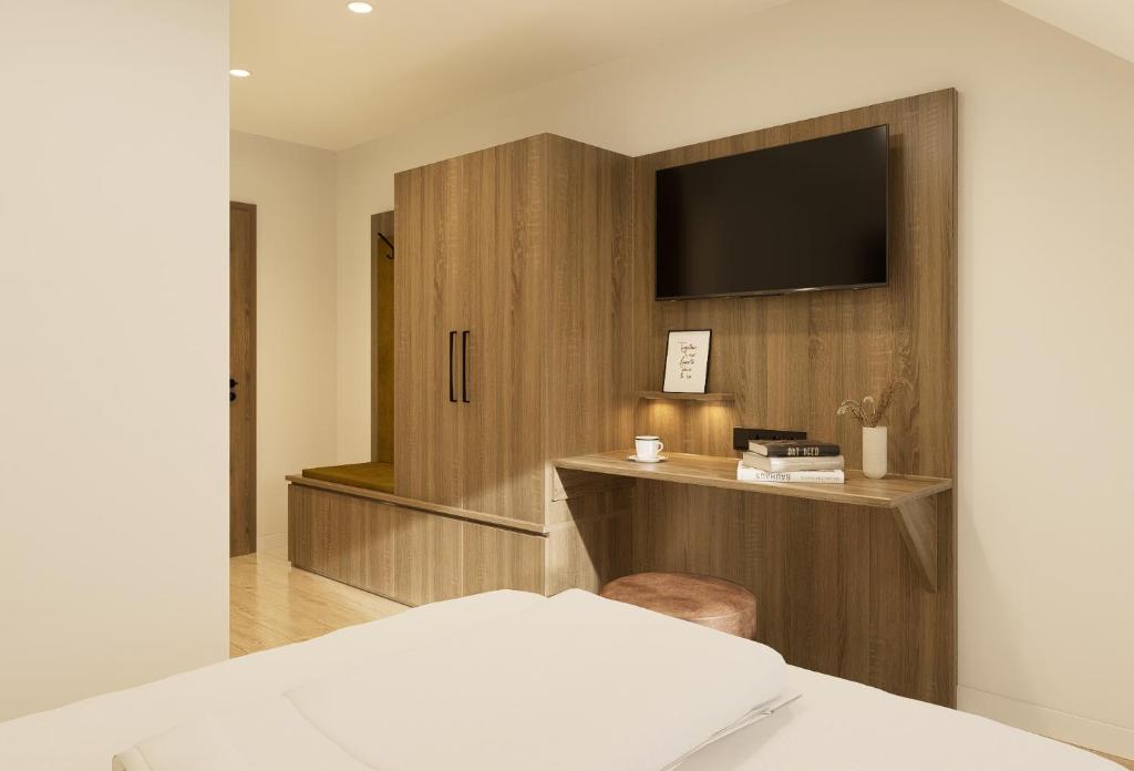 a bedroom with a bed and a tv on a wall at "NEU" Apartments-Hotel Huberhof Allershausen in Allershausen