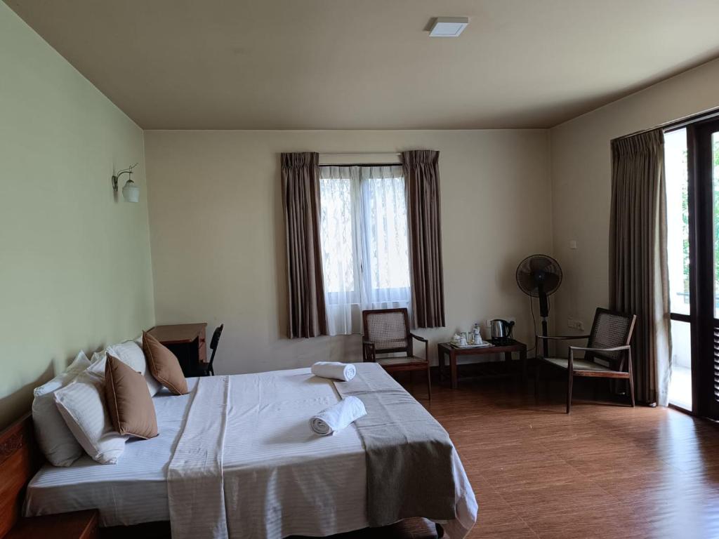 1 dormitorio con 1 cama grande y sala de estar en Shalom, en Peradeniya