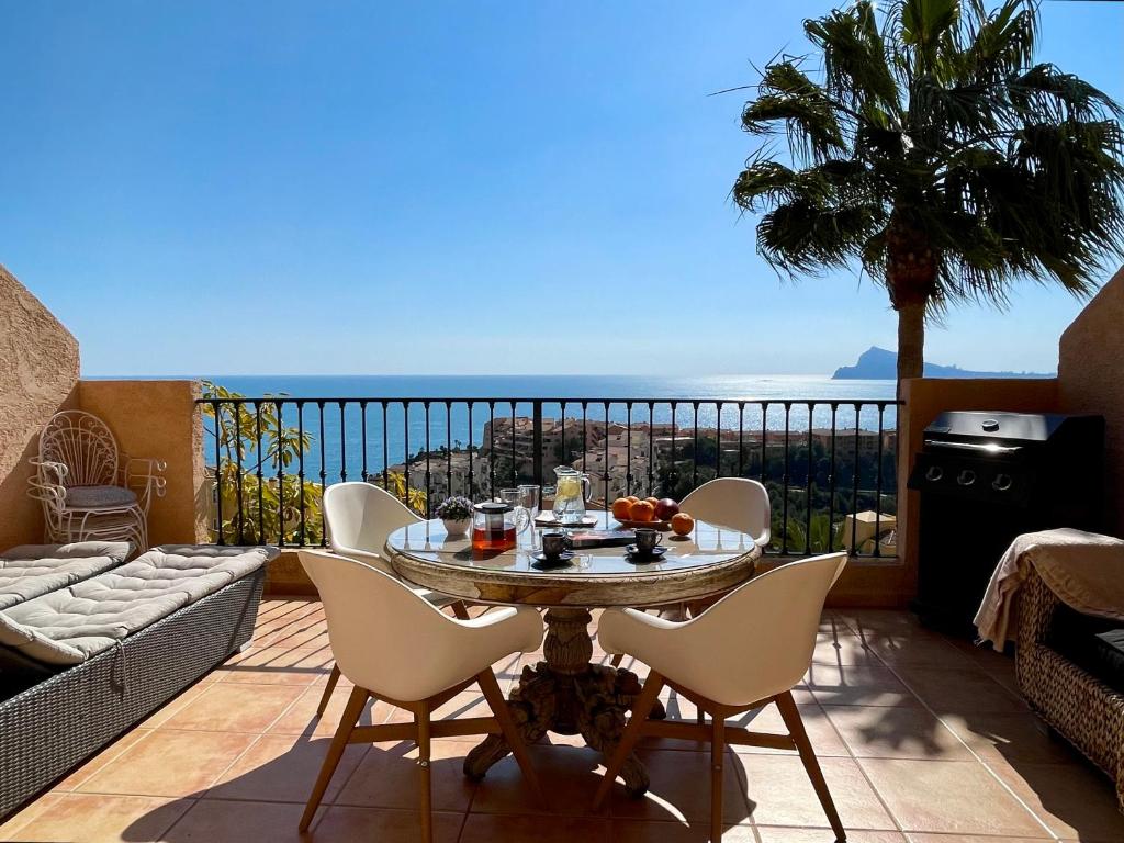 een tafel en stoelen op een balkon met uitzicht op de oceaan bij Mascarat Hills Сalpe&Altea Incredible view in Altea la Vieja